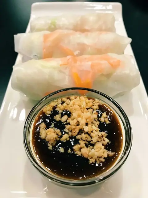 Fresh salad rolls in rice paper with a bowl of peanut sauce